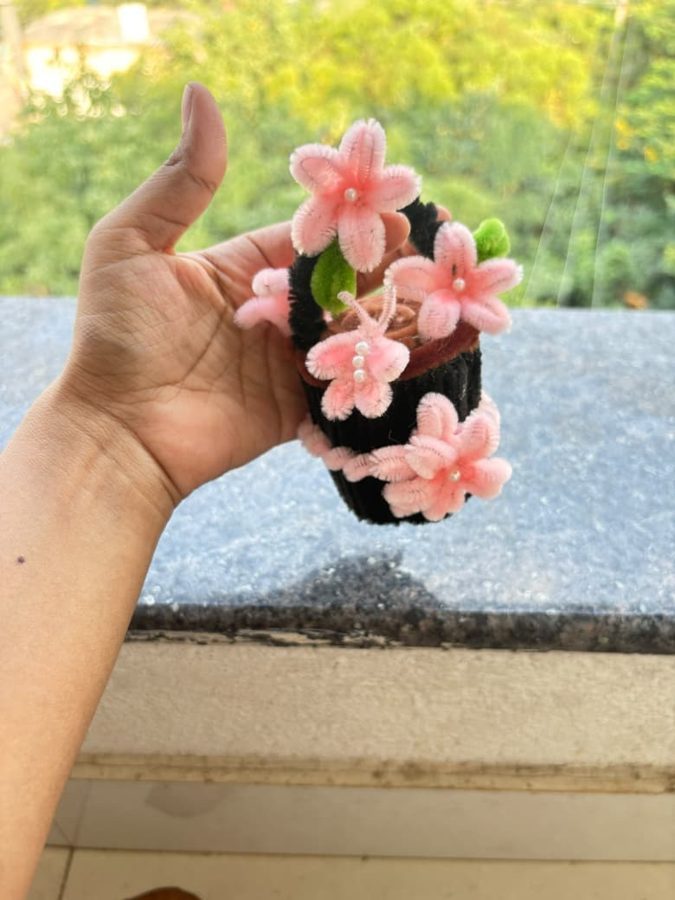 Blush Blossom Basket. Handcrafted mini flower basket made from soft chenille wire, with pink blossoms, pearl centers, and green leaves. Set in a black knitted base with a black handle. A soft, pretty gift for any desk…