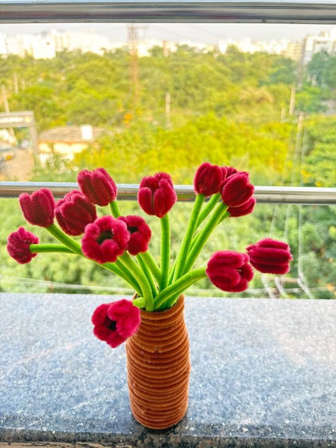 Magenta Tulip Vase. Handcrafted tulip bouquet made from soft chenille wire, with deep magenta blooms on bright green stems. Set in a coiled orange-brown vase. A vibrant centerpiece for any desk or shelf.