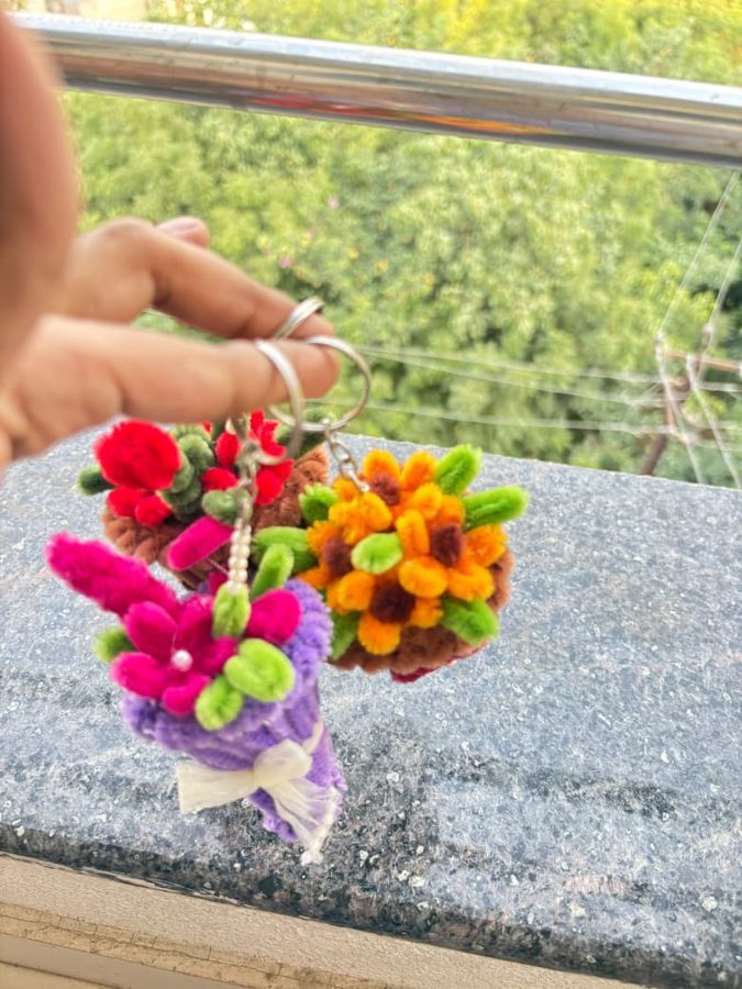 Petal Posy Keychain. Handcrafted mini bouquet keychain made from soft chenille wire, with bright flowers, green leaves, and a pearl accent. Comes in assorted colors. A cute add-on for keys or bags.
