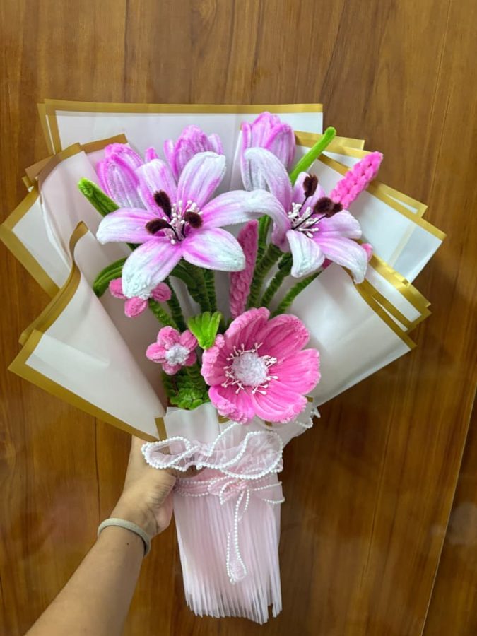 A wrapped pink lily and tulip chenille bouquet with a pearl-beaded ribbon.
